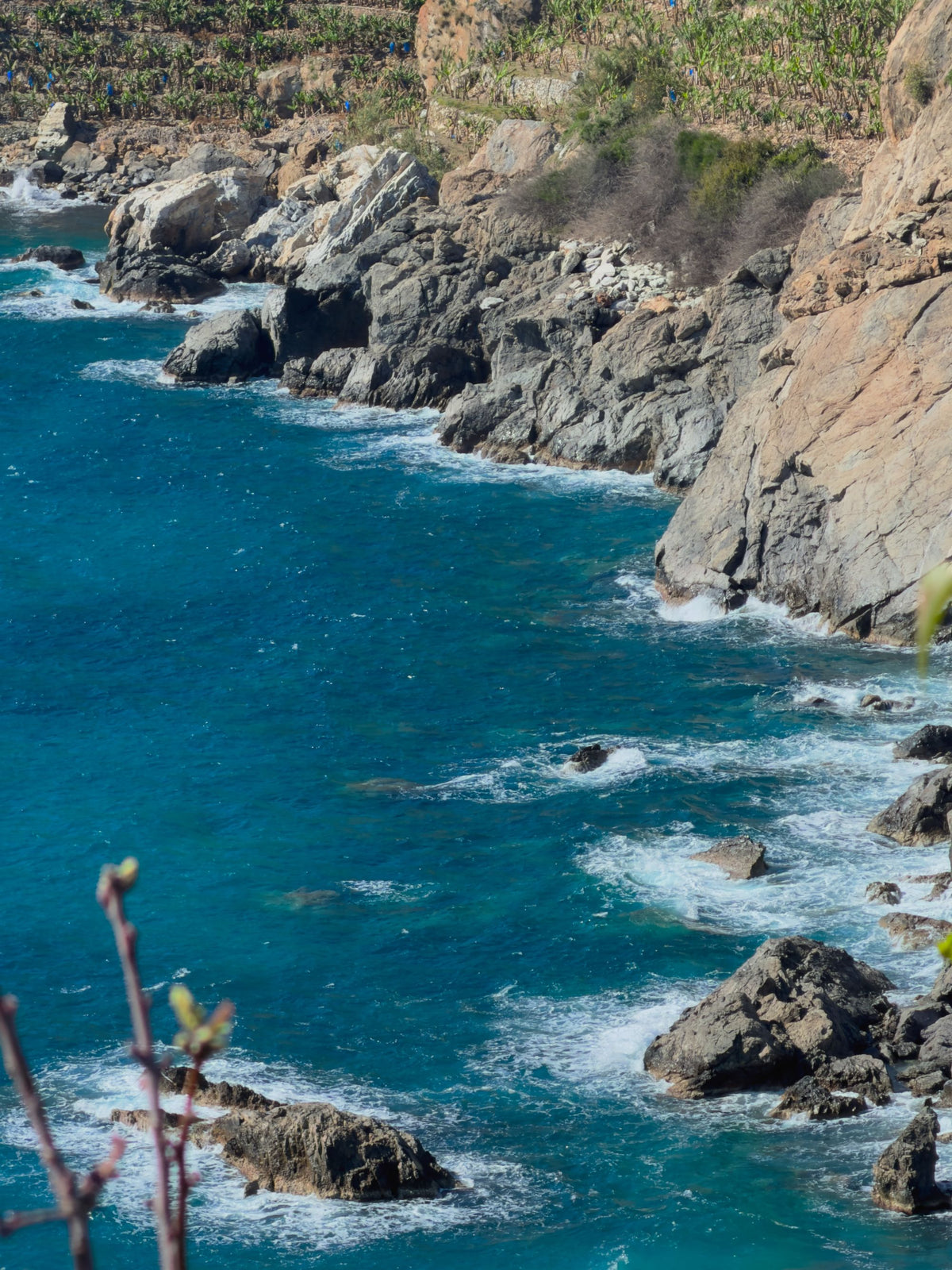 Rugged rocky coastline and turquoise Atlantic water below a clifftop on the Bay of Biscay