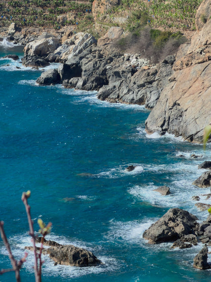 Rugged rocky coastline and turquoise Atlantic water below a clifftop on the Bay of Biscay