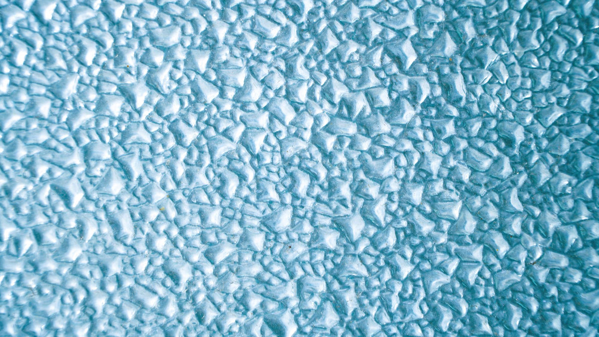 Close detail of a textured icy blue surface, cold to the touch.