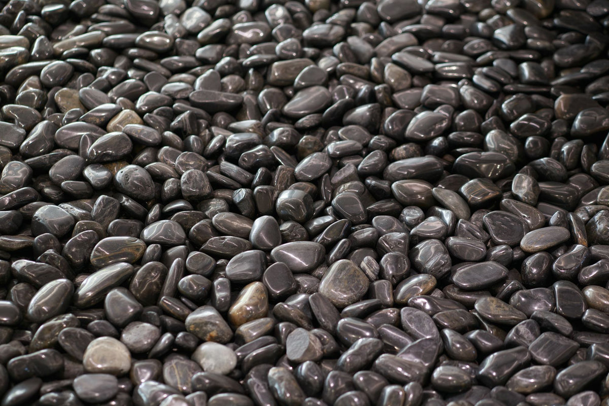 Smooth dark stones in close up, evoking the Lake District slate around Brimstone Spa