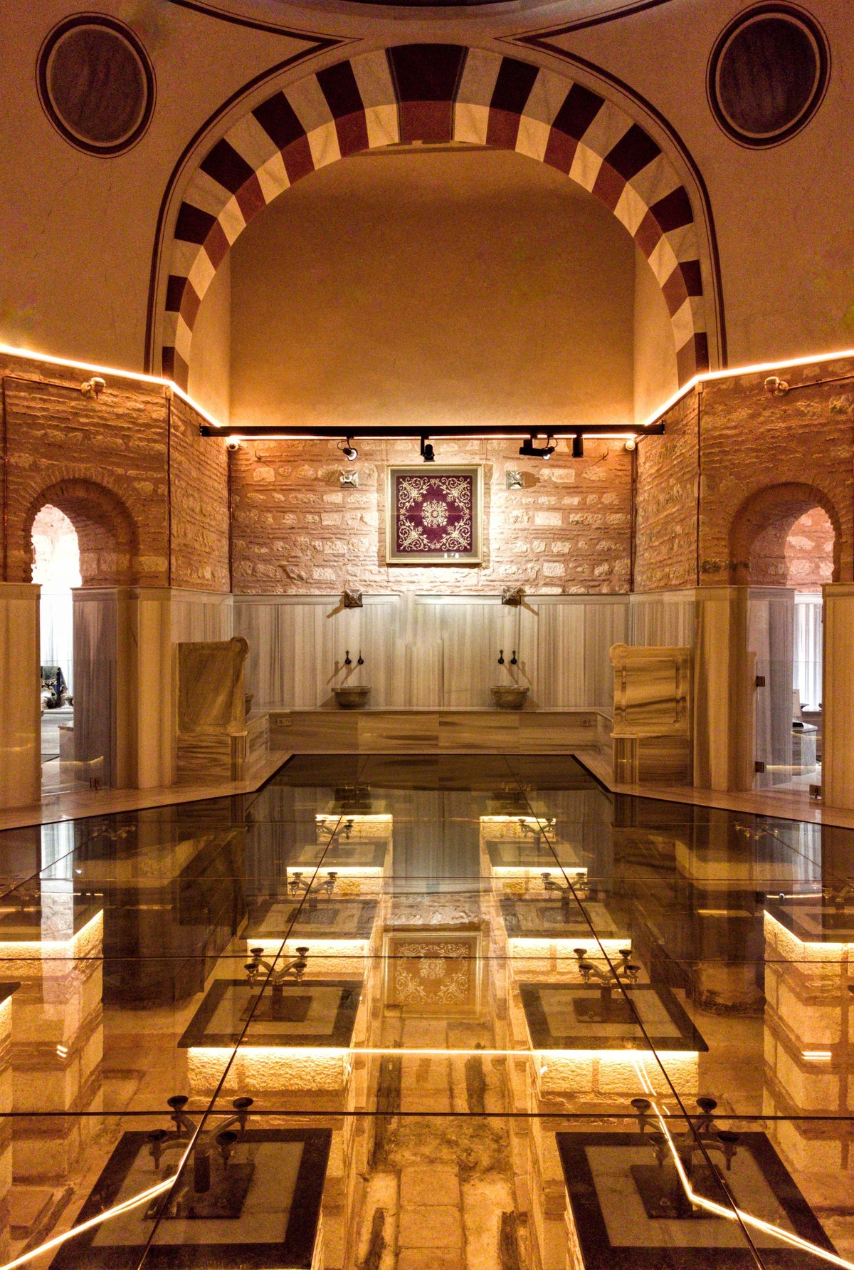Warm golden light inside an ornate hammam steam room, evoking the heat circuit at a Paris hotel spa