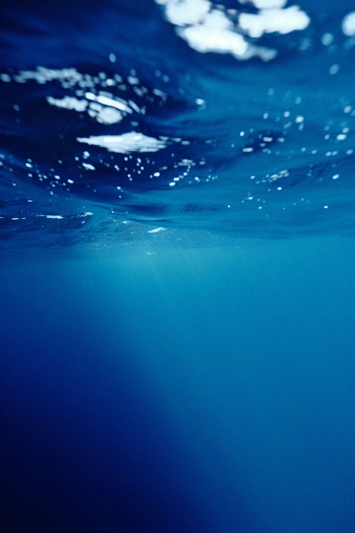 Deep blue underwater light filtering down through clear water