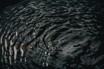Ripples crossing dark water in low golden light, Aman Spa at The Connaught