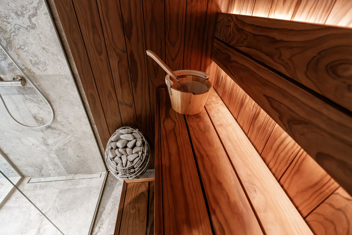 Wooden sauna interior with a stone bucket and ladle, evoking the heat circuit at Akelarre's spa