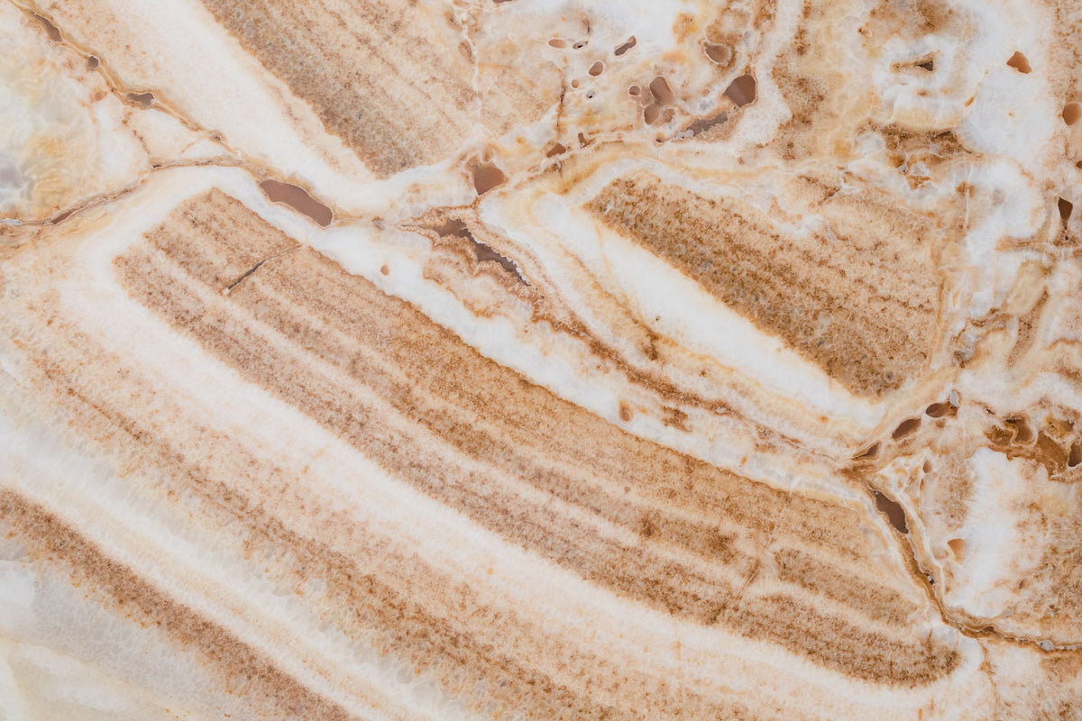 Banded cream and caramel onyx stone in close up, evoking the white onyx bathrooms in each of the six Dior treatment suites