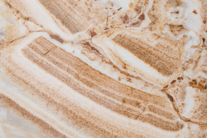 Banded cream and caramel onyx stone in close up, evoking the white onyx bathrooms in each of the six Dior treatment suites