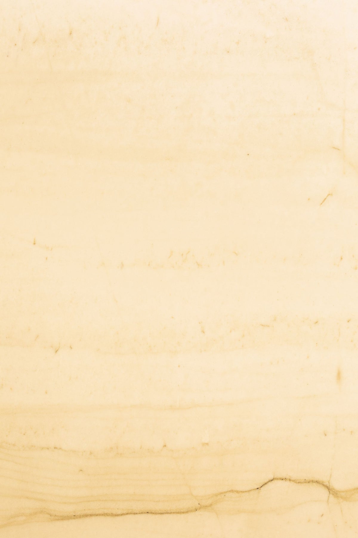 Close detail of pale warm toned marble, veined and softly lit