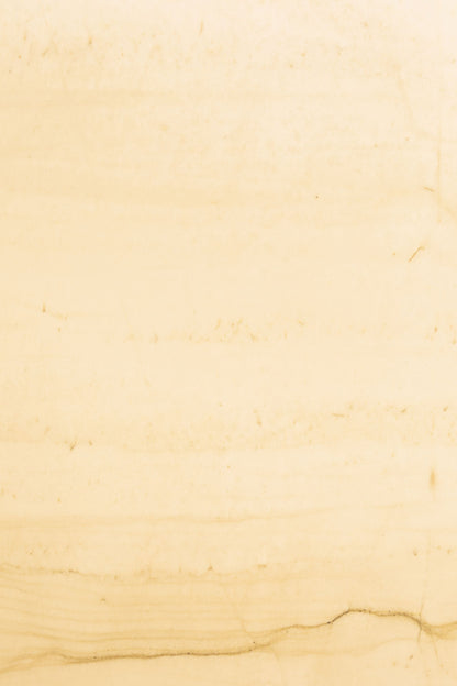 Close detail of pale warm toned marble, veined and softly lit