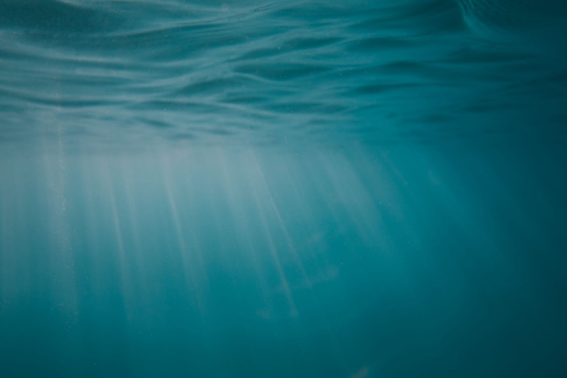 Sunlight filtering through clear blue green water.