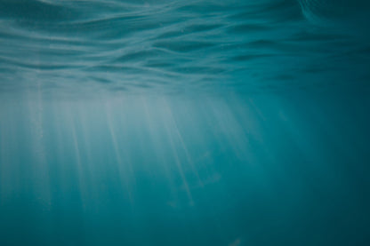 Sunlight filtering through clear blue green water.