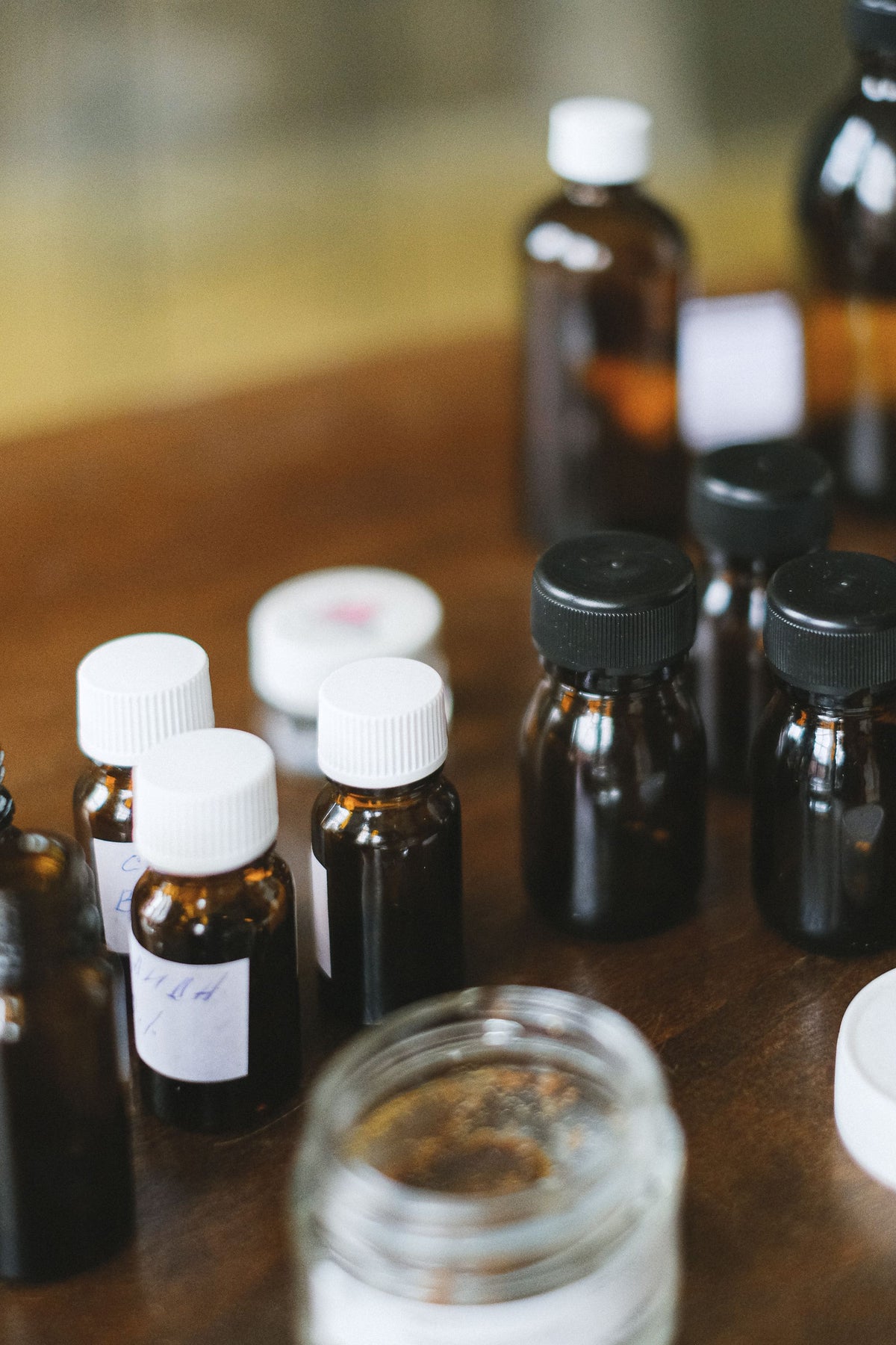 Amber glass bottles glowing in warm light, evoking the herbal tonics tasted before the Monks' Elixir treatment