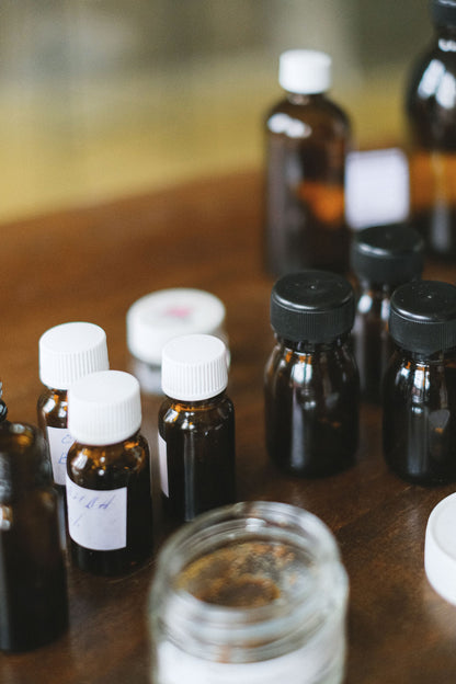 Amber glass bottles glowing in warm light, evoking the herbal tonics tasted before the Monks' Elixir treatment