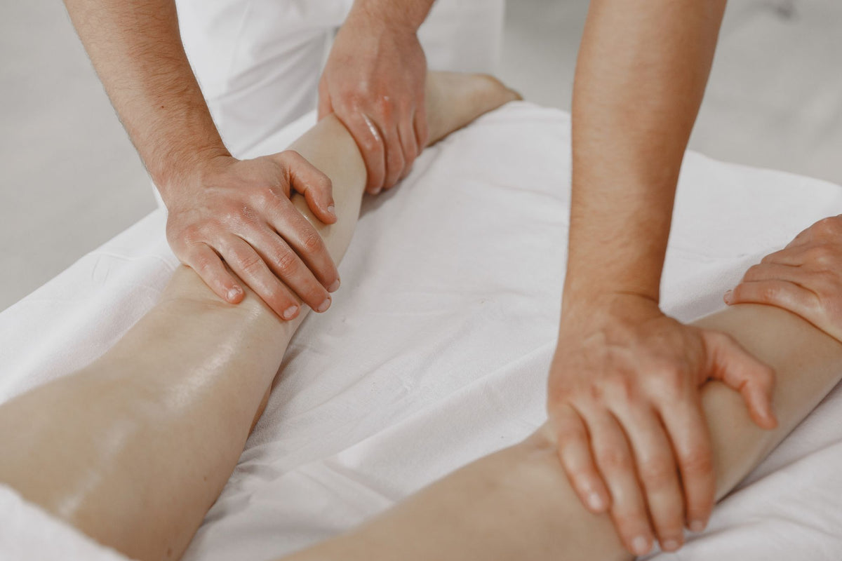 A therapist's hands at work on a guest's legs during a treatment