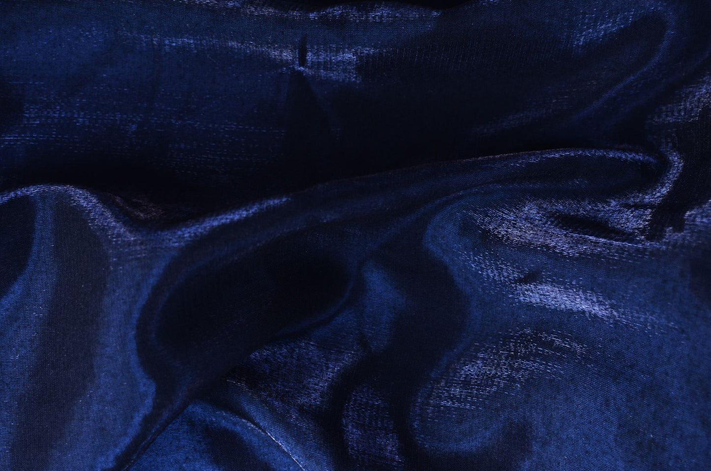 Deep midnight blue fabric caught in a low raking light, the feeling of the blue upholstered walls at Asaya at The Chancery Rosewood