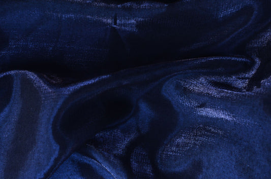 Deep midnight blue fabric caught in a low raking light, the feeling of the blue upholstered walls at Asaya at The Chancery Rosewood