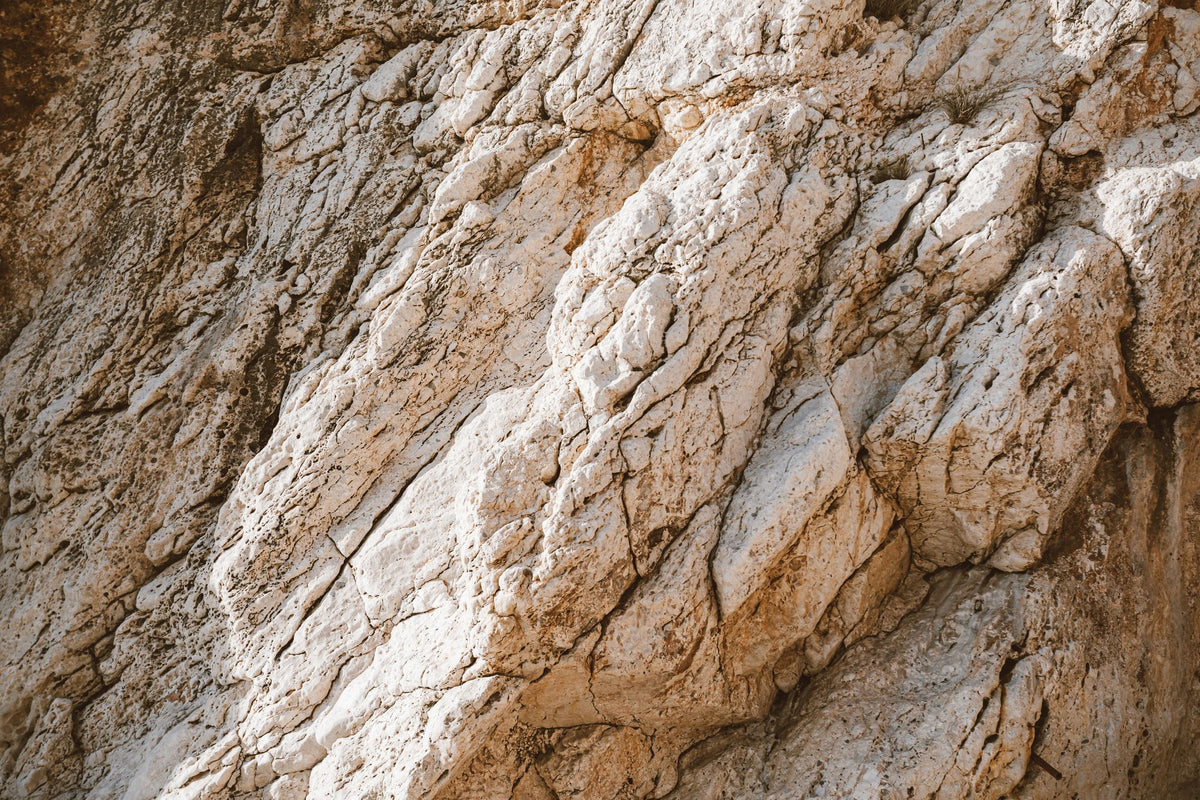 Pale weathered limestone rock face in warm light, evoking the stone of the Sierra Helada above Albir