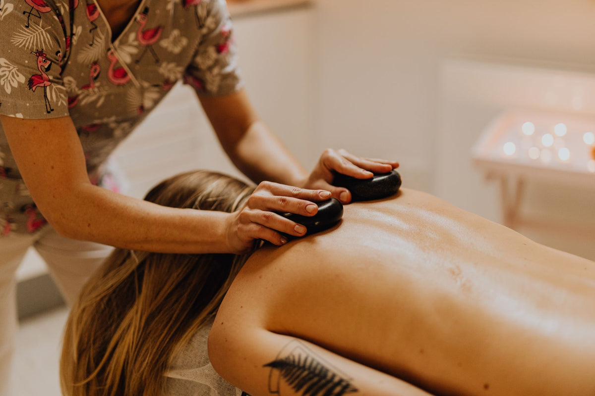 A hot stone massage session in a warm lit treatment room