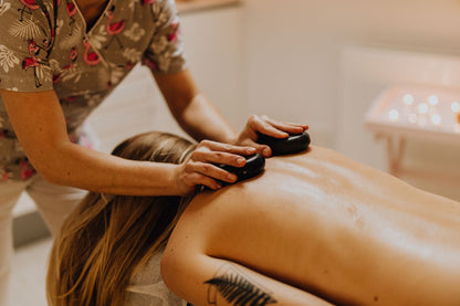 A hot stone massage session in a warm lit treatment room