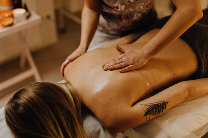 A back massage with warm oil, softly lit