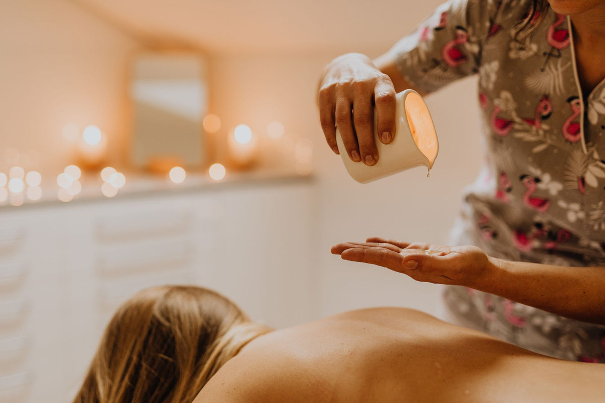 A therapist pouring massage oil by candlelight at Ritz Paris Club & Spa.