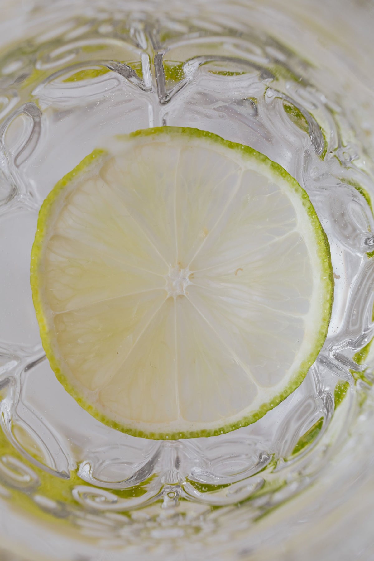 A slice of citrus suspended in a glass of water