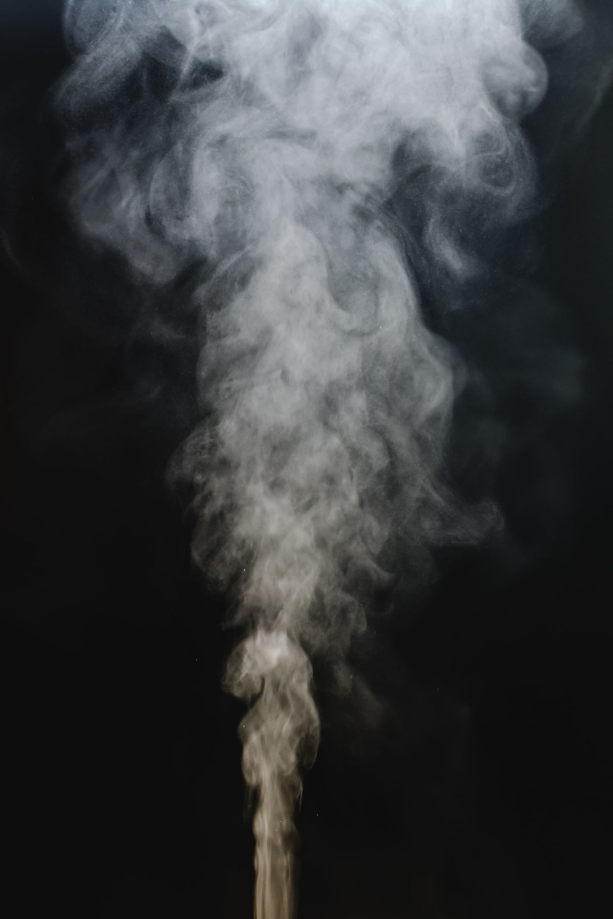 Steam rising through dark still air, evoking the warmth of a stone steam bath in a Spanish abbey spa