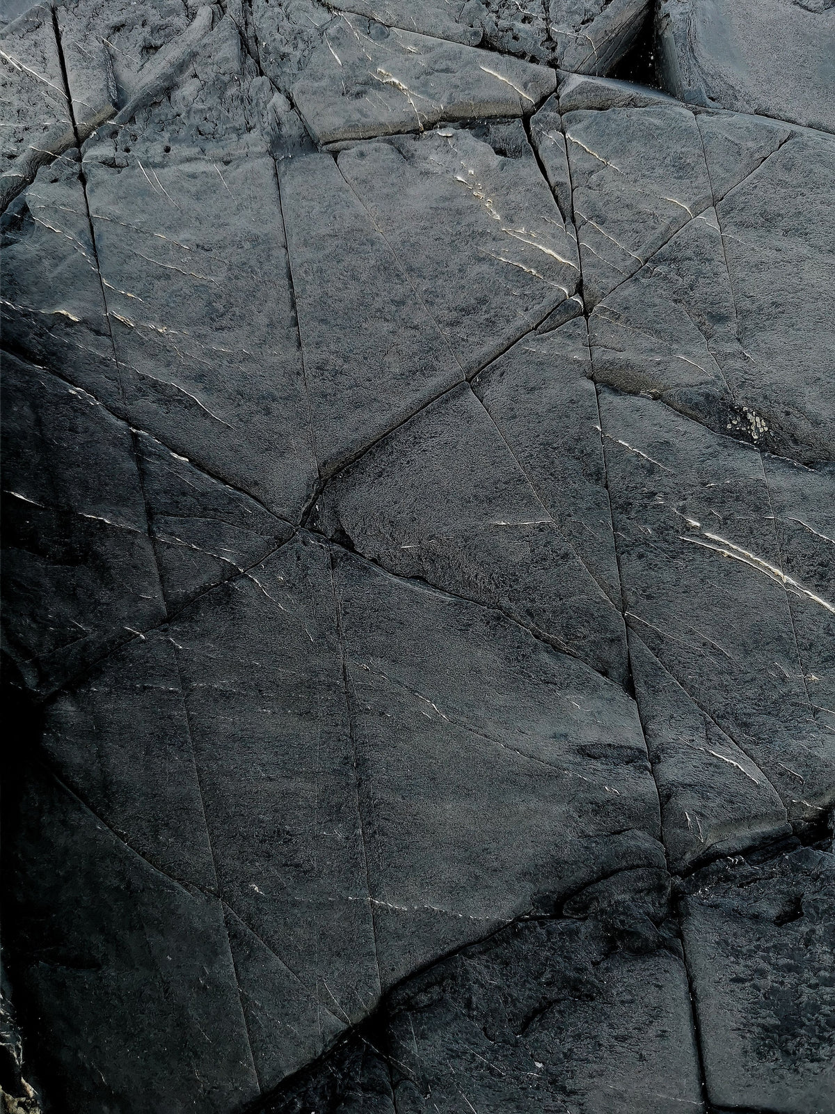 Wet slate split into dark angular planes, C-Side Spa at Cowley Manor, Cheltenham