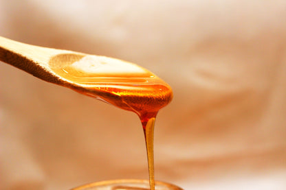 Honey running from a golden spoon