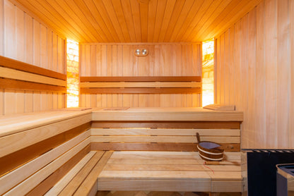 Sunlit cedar sauna benches glow warm gold under soft overhead light.
