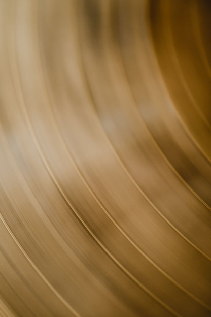 Warm brass curving away in soft focus, echoing the bronze core at Lanserhof at The Arts Club