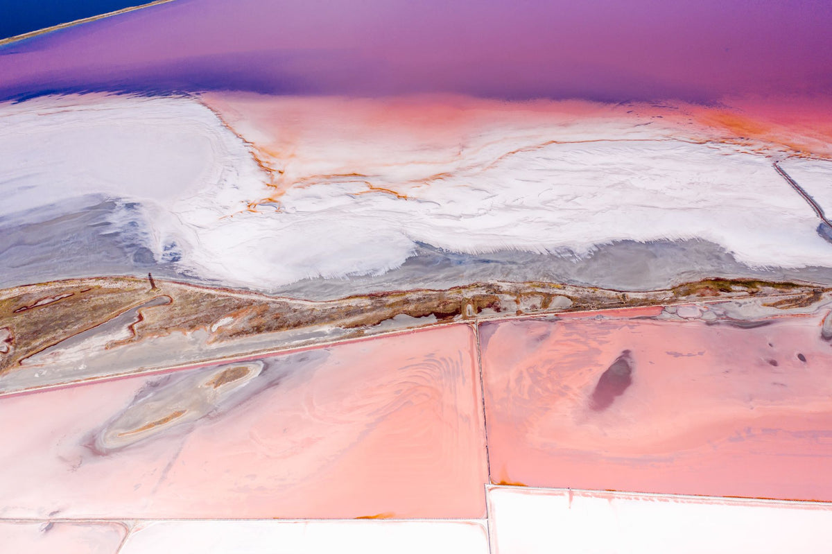 Aerial view of pink-hued salt flats, evoking the nearby Es Salobrar