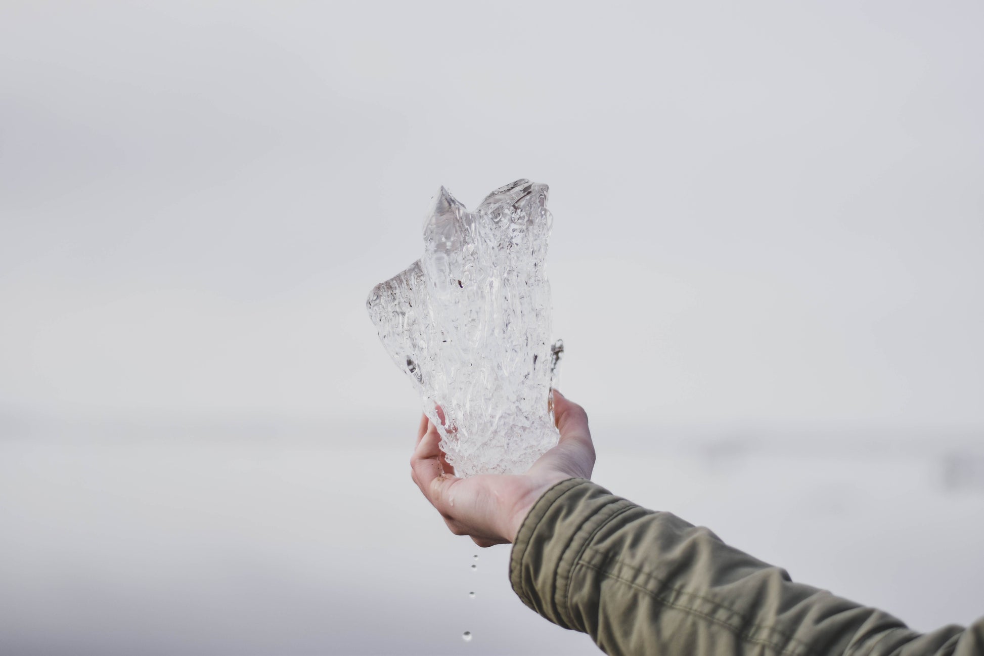 A shard of ice held up against a cold winter sky, Calcot Spa, Tetbury
