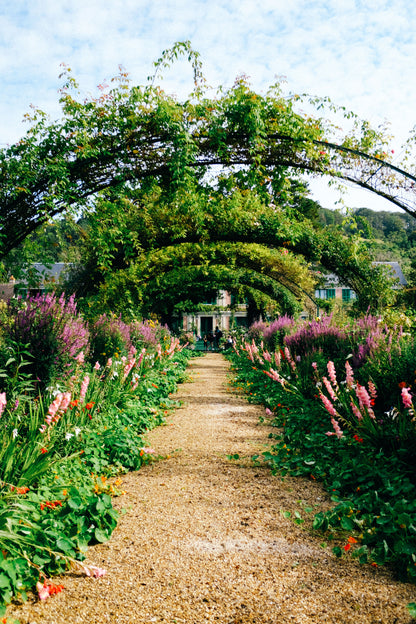 A path running under an arch through a planted walled garden, The Meadow Spa at Thyme, Southrop