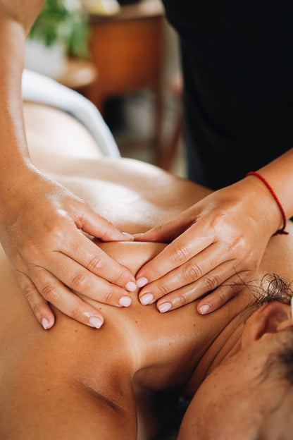 A therapist's hands resting on a back at the close of a massage.