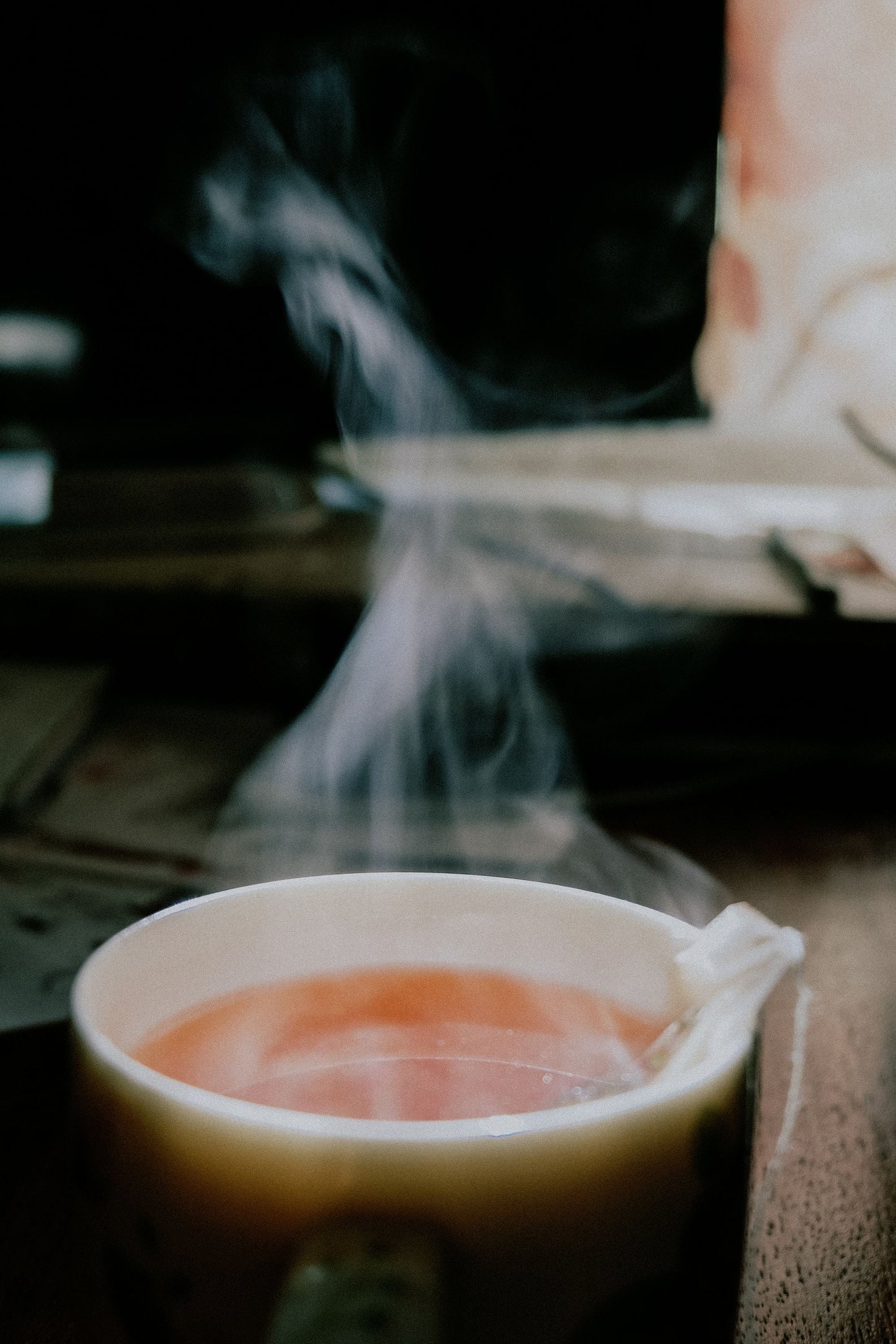 Steam curling from a cup of herbal tea in low warm light, Surrenne at The Emory