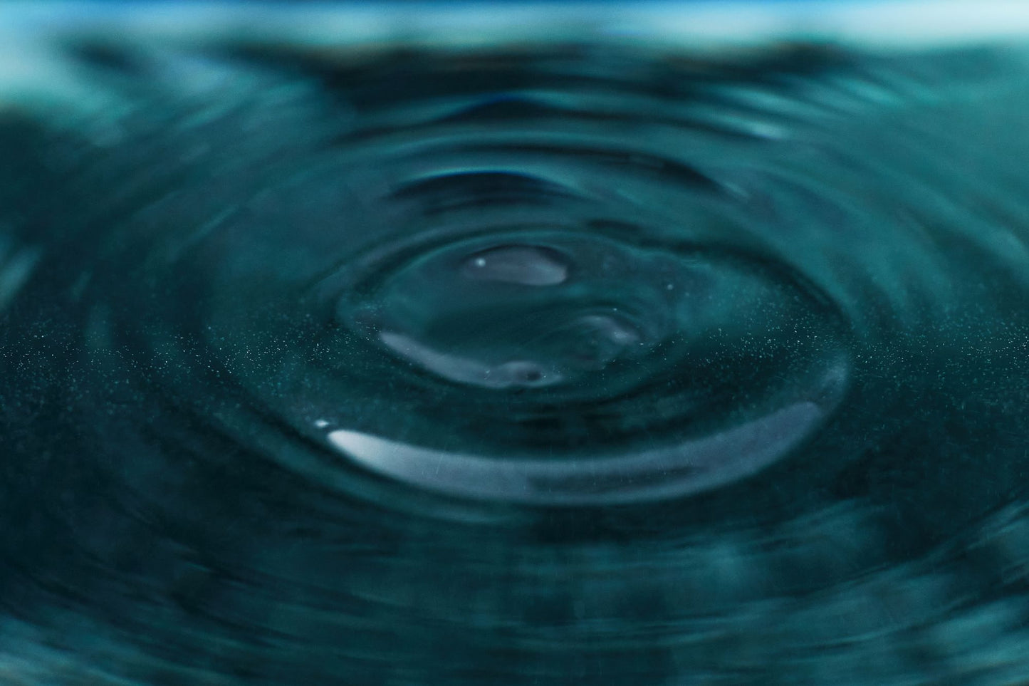 A close view of a single ripple crossing a still water surface