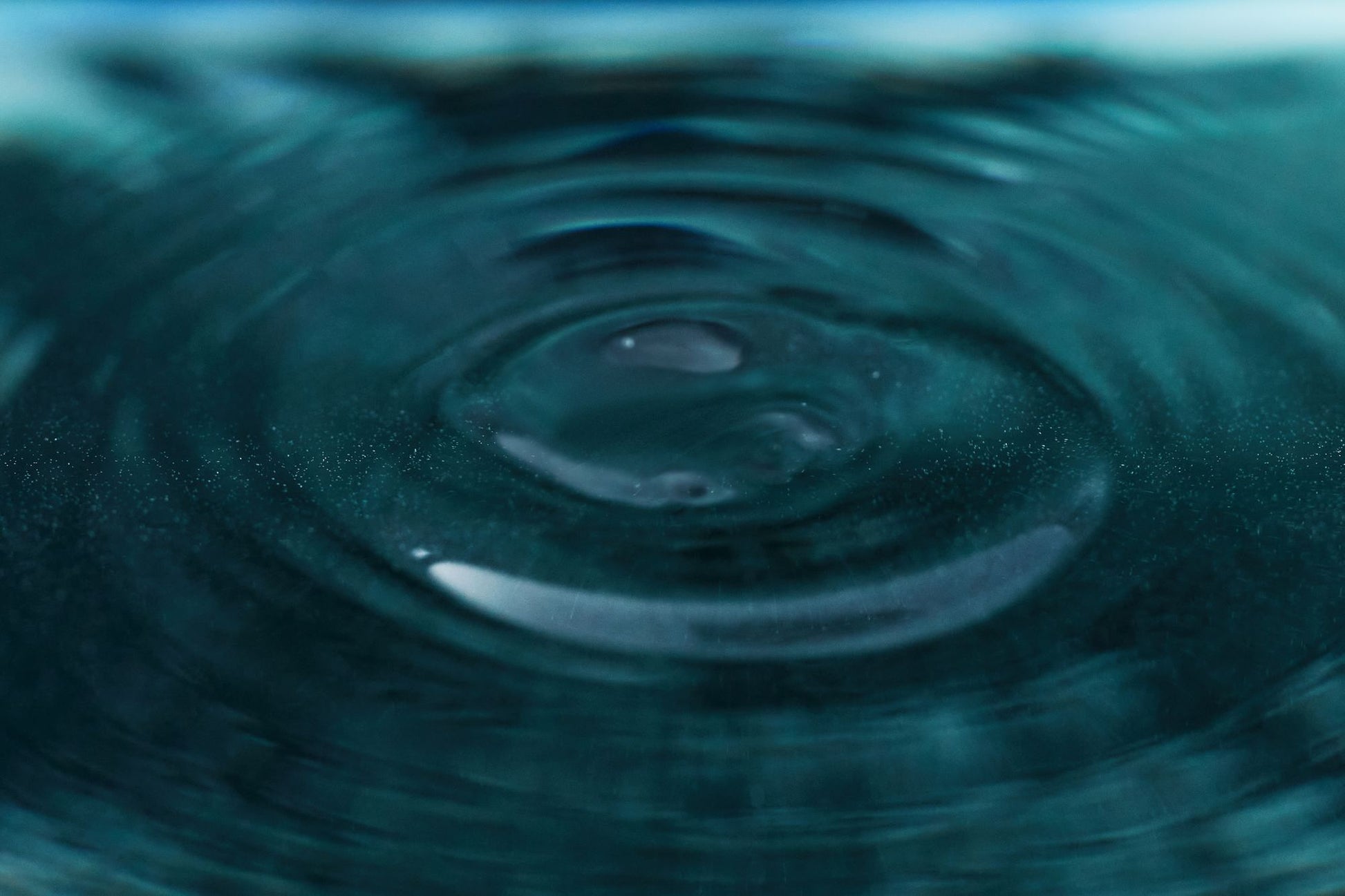 A close view of a single ripple crossing a still water surface