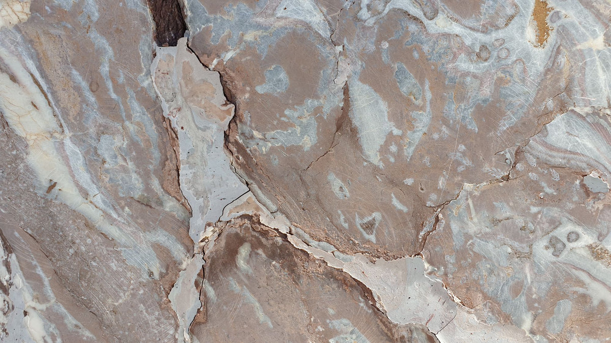 Weathered stone with deep brown and blue grey veining running through it.
