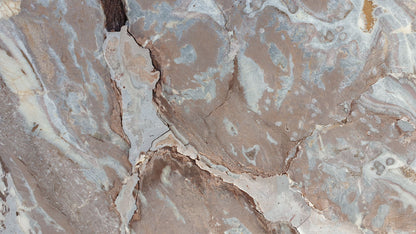 Weathered stone with deep brown and blue grey veining running through it.